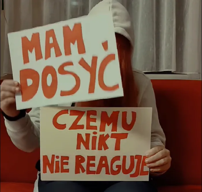 Osoba trzymająca dwie plansze z napisami