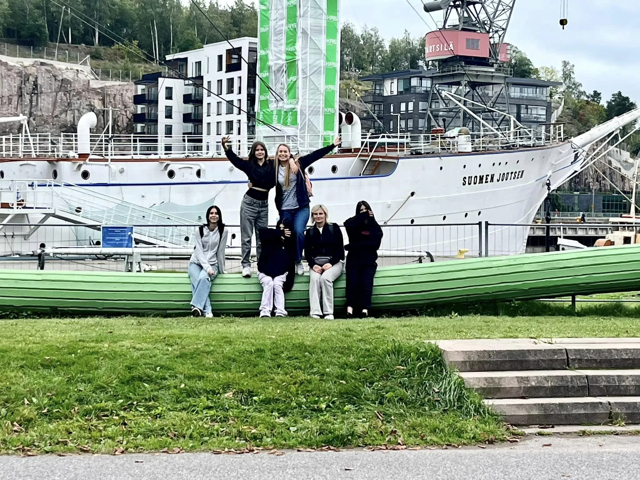 Osoby stoją na tle statku