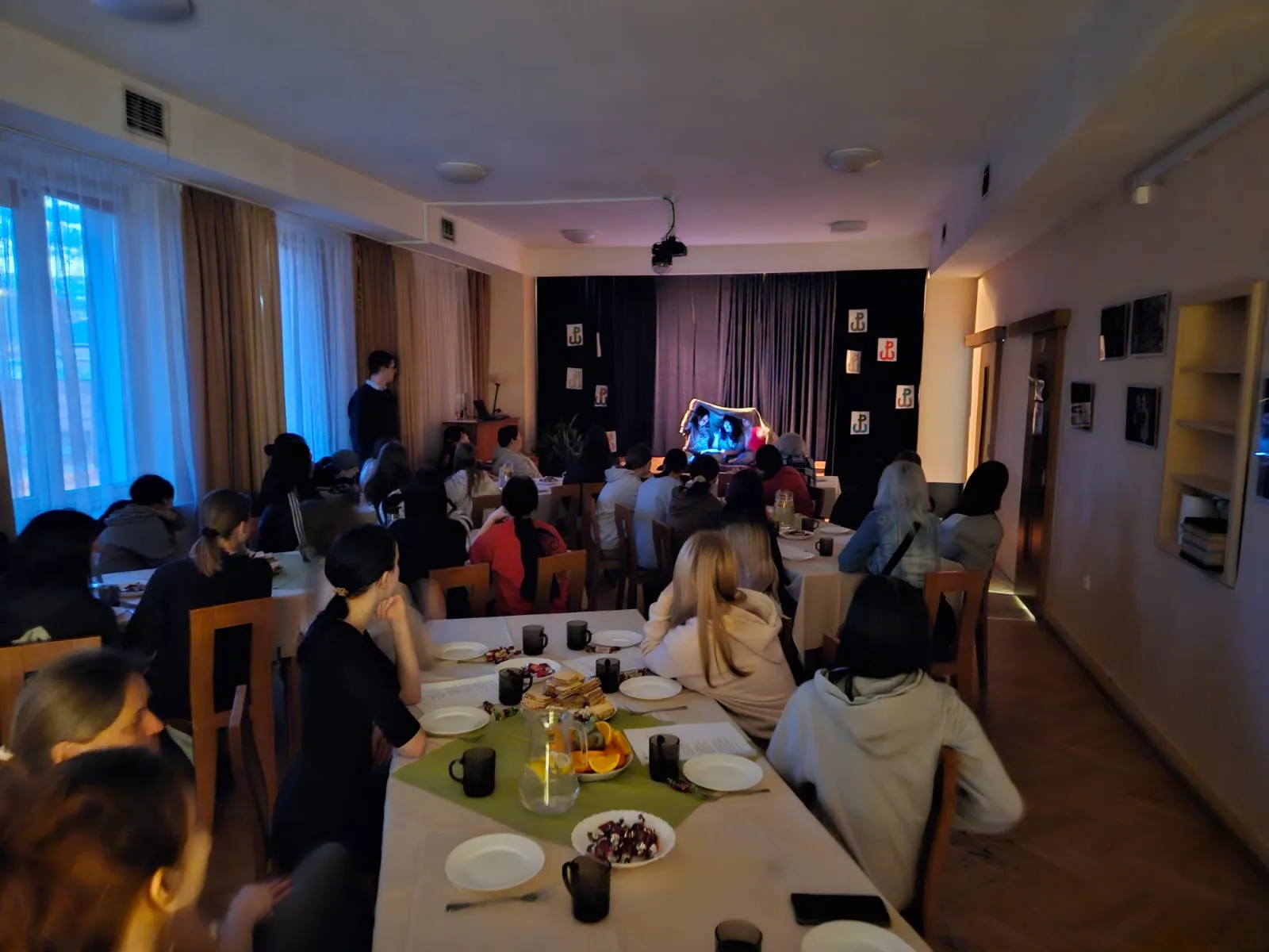 Młodzież siedzi przy stołach