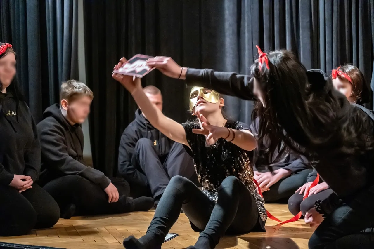 Osoby na scenie odgrywają spektakl teatralny