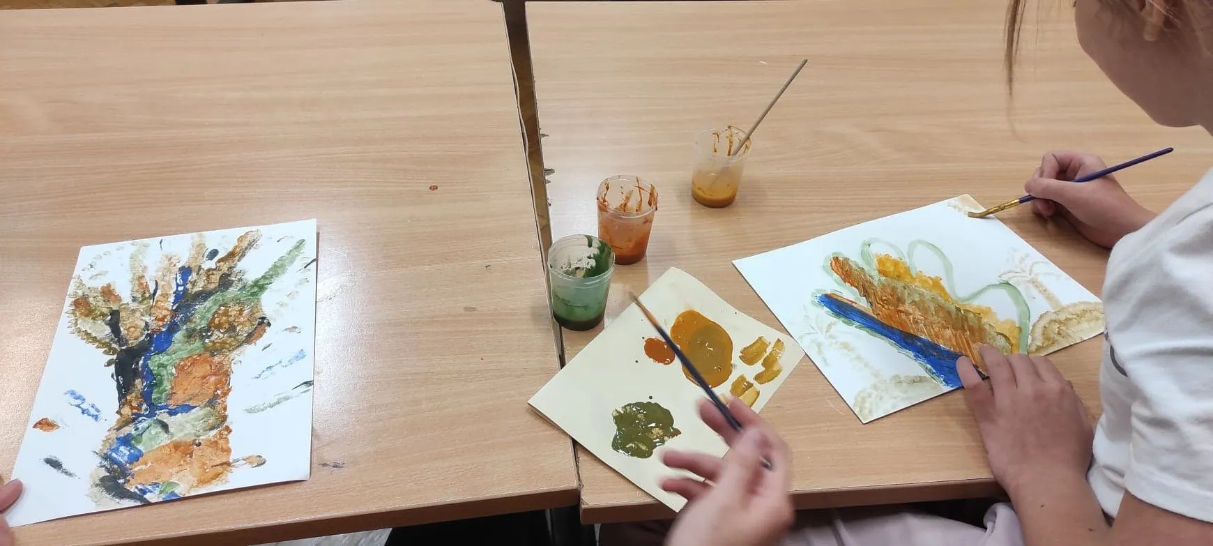 Osoby malują na kartkach