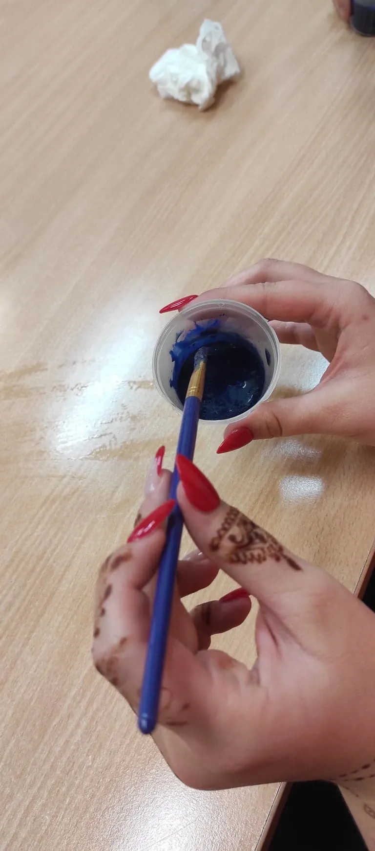 Osoba macza pędzelek w farbie